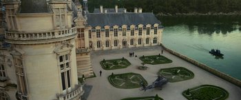 Movie still from “The Gray Man” (2022), directed by Joe Russo – An aerial view of a castle with a helicopter parked in front of it; Extreme Wide shot, High angle