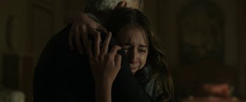 Movie still from “The Gray Man” (2022), directed by Joe Russo – A woman is crying while hugging a man; Close Up shot, Over the shoulder angle