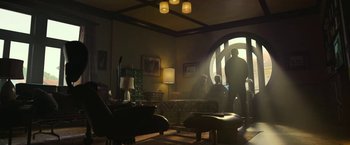 Movie still from “The Gray Man” (2022), directed by Joe Russo – A group of people in a living room with lamps; Wide shot, Low angle