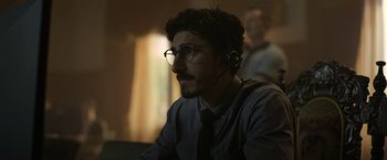 Movie still from “The Gray Man” (2022), directed by Joe Russo – A man wearing a headset and a tie; Close Up shot, Low angle