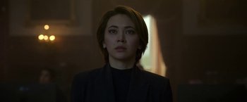 Movie still from “The Gray Man” (2022), directed by Joe Russo – A woman in a black jacket is looking straight ahead; Close Up shot, Over the shoulder angle
