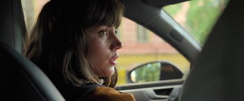 Movie still from “The Gray Man” (2022), directed by Joe Russo – A woman sitting in the driver's seat of a car; Close Up shot, Over the shoulder angle