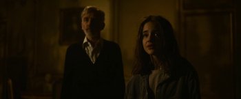 Movie still from “The Gray Man” (2022), directed by Joe Russo – A man and a woman standing next to each other in the dark; Medium shot, Over the shoulder angle