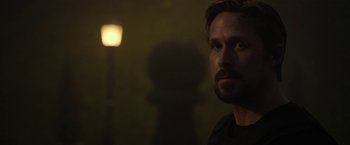 Movie still from “The Gray Man” (2022), directed by Joe Russo – A person in a dark room; Close Up shot, Over the shoulder angle