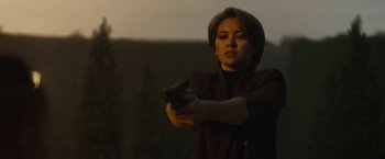 Movie still from “The Gray Man” (2022), directed by Joe Russo – A woman is holding a gun in her hand; Medium shot, Low angle