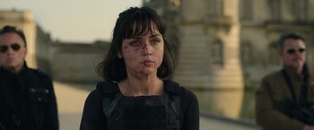 Movie still from “The Gray Man” (2022), directed by Joe Russo – A woman with a black shirt and a black shirt and a black shirt; Close Up shot, Over the shoulder angle