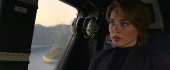 Movie still from “The Gray Man” (2022), directed by Joe Russo – A woman sitting in the cockpit of a helicopter; Close Up shot, Over the shoulder angle