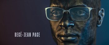 Movie still from “The Gray Man” (2022), directed by Joe Russo – A man's face wearing glasses; Extreme Close Up shot, Overhead angle