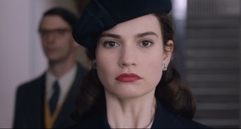 Movie still from “The Guernsey Literary and Potato Peel Pie Society” (2018), directed by Mike Newell – A person wearing a hat; Close Up shot, Low angle