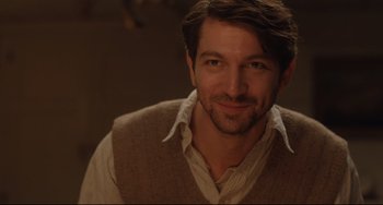 Movie still from “The Guernsey Literary and Potato Peel Pie Society” (2018), directed by Mike Newell – A person wearing a shirt and a vest; Close Up shot, Over the shoulder angle