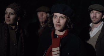 Movie still from “The Guernsey Literary and Potato Peel Pie Society” (2018), directed by Mike Newell – A young woman wearing a beret and a scarf; Close Up shot, Over the shoulder angle