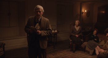 Movie still from “The Guernsey Literary and Potato Peel Pie Society” (2018), directed by Mike Newell – An older man and a woman in a living room; Medium shot, Over the shoulder angle