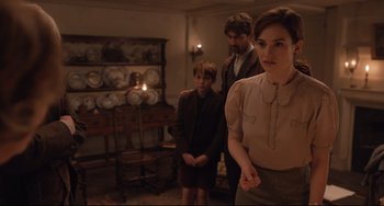 Movie still from “The Guernsey Literary and Potato Peel Pie Society” (2018), directed by Mike Newell – A woman and two men in a room; Medium shot, Over the shoulder angle