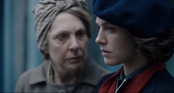 Movie still from “The Guernsey Literary and Potato Peel Pie Society” (2018), directed by Mike Newell – A woman and a man are standing next to each other; Close Up shot, Over the shoulder angle