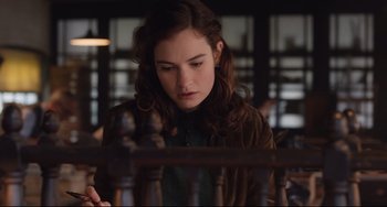 Movie still from “The Guernsey Literary and Potato Peel Pie Society” (2018), directed by Mike Newell – A young woman is looking down at a chess board; Medium shot, Over the shoulder angle