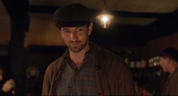 Movie still from “The Guernsey Literary and Potato Peel Pie Society” (2018), directed by Mike Newell – A person wearing a hat; Close Up shot, Over the shoulder angle