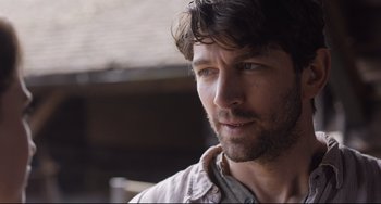 Movie still from “The Guernsey Literary and Potato Peel Pie Society” (2018), directed by Mike Newell – A person wearing a shirt; Close Up shot, Over the shoulder angle