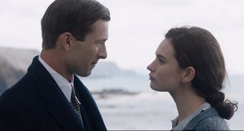 Movie still from “The Guernsey Literary and Potato Peel Pie Society” (2018), directed by Mike Newell – A man and a woman standing next to each other on the beach; Close Up shot, Over the shoulder angle