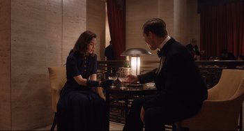 Movie still from “The Guernsey Literary and Potato Peel Pie Society” (2018), directed by Mike Newell – A man and a woman sitting at a dinner table; Medium shot, High angle