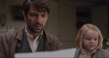 Movie still from “The Guernsey Literary and Potato Peel Pie Society” (2018), directed by Mike Newell – A man and a woman looking at a piece of paper; Close Up shot, Over the shoulder angle