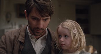 Movie still from “The Guernsey Literary and Potato Peel Pie Society” (2018), directed by Mike Newell – A man and a little girl standing next to each other; Close Up shot, Over the shoulder angle