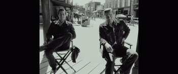 Movie still from “Once Upon a Time in Hollywood” (2019), directed by Quentin Tarantino – A black and white photo of two men sitting in chairs; Wide shot, Low angle
