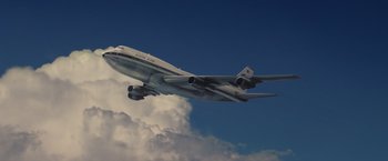 Movie still from “Once Upon a Time in Hollywood” (2019), directed by Quentin Tarantino – An airplane is flying in the sky under a cloudy sky; Extreme Wide shot, Low angle