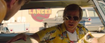 Movie still from “Once Upon a Time in Hollywood” (2019), directed by Quentin Tarantino – A man in a yellow shirt driving a car; Medium shot, Over the shoulder angle