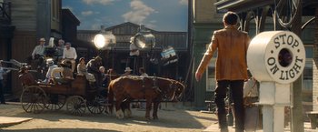 Movie still from “Once Upon a Time in Hollywood” (2019), directed by Quentin Tarantino – A man walking a horse drawn carriage down a street; Wide shot, Low angle