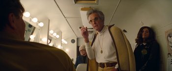 Movie still from “Once Upon a Time in Hollywood” (2019), directed by Quentin Tarantino – An older man smoking a cigarette on a train; Medium shot, Low angle