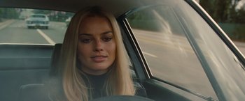 Movie still from “Once Upon a Time in Hollywood” (2019), directed by Quentin Tarantino – A woman sitting in the driver's seat of a car; Close Up shot, Over the shoulder angle
