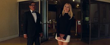 Movie still from “Once Upon a Time in Hollywood” (2019), directed by Quentin Tarantino – A woman standing in front of a man in a tuxedo; Medium shot, Over the shoulder angle