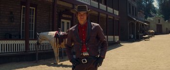 Movie still from “Once Upon a Time in Hollywood” (2019), directed by Quentin Tarantino – A man in a cowboy hat and a jacket stands in front of a horse; Medium shot, Over the shoulder angle