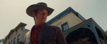 Movie still from “Once Upon a Time in Hollywood” (2019), directed by Quentin Tarantino – A man wearing a cowboy hat and a brown jacket; Close Up shot, Low angle