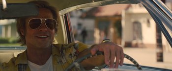 Movie still from “Once Upon a Time in Hollywood” (2019), directed by Quentin Tarantino – A man driving a car in a city street; Close Up shot, Low angle
