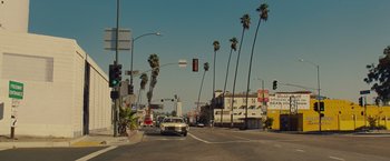 Movie still from “Once Upon a Time in Hollywood” (2019), directed by Quentin Tarantino – A street scene with palm trees and a car driving down the street; Extreme Wide shot, High angle