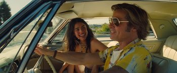 Movie still from “Once Upon a Time in Hollywood” (2019), directed by Quentin Tarantino – A man and a woman sitting in the back seat of a car; Medium shot, Over the shoulder angle
