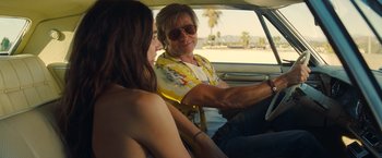 Movie still from “Once Upon a Time in Hollywood” (2019), directed by Quentin Tarantino – A man and a woman sitting in the drivers seat of a car; Medium shot, Over the shoulder angle