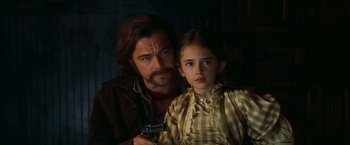 Movie still from “Once Upon a Time in Hollywood” (2019), directed by Quentin Tarantino – A man and a young girl holding a gun; Close Up shot, Over the shoulder angle
