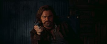Movie still from “Once Upon a Time in Hollywood” (2019), directed by Quentin Tarantino – A man holding a gun while sitting in a chair; Close Up shot, Low angle