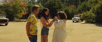 Movie still from “Once Upon a Time in Hollywood” (2019), directed by Quentin Tarantino – Two women and a man standing in the sand; Medium shot, Over the shoulder angle