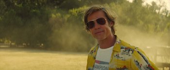 Movie still from “Once Upon a Time in Hollywood” (2019), directed by Quentin Tarantino – A person wearing sunglasses and a yellow shirt; Close Up shot, Low angle