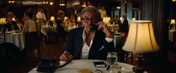 Movie still from “Once Upon a Time in Hollywood” (2019), directed by Quentin Tarantino – An older man sitting at a table talking on the phone; Medium shot, Low angle