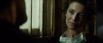 Movie still from “The Gunman” (2015), directed by Pierre Morel – A woman standing in front of a window; Close Up shot, Over the shoulder angle