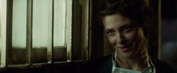 Movie still from “The Gunman” (2015), directed by Pierre Morel – A young woman standing in front of an open window; Close Up shot, Over the shoulder angle