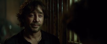 Movie still from “The Gunman” (2015), directed by Pierre Morel – A person wearing a black shirt; Close Up shot, Over the shoulder angle