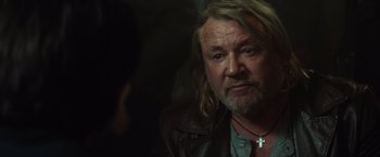 Movie still from “The Gunman” (2015), directed by Pierre Morel – A person wearing a leather jacket; Close Up shot, Over the shoulder angle