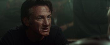 Movie still from “The Gunman” (2015), directed by Pierre Morel – A person wearing a black t - shirt; Close Up shot, Over the shoulder angle