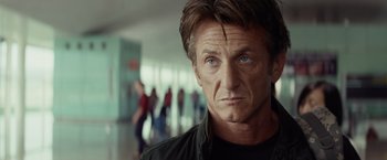 Movie still from “The Gunman” (2015), directed by Pierre Morel – A person wearing a black shirt; Close Up shot, Over the shoulder angle