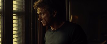 Movie still from “The Gunman” (2015), directed by Pierre Morel – A person wearing a black t - shirt; Close Up shot, Low angle